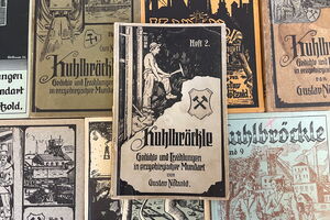 Es ist ein geschlossenes Heft abgebildet. Auf der Titelseite steht in der unteren Hälfte der Text „Kuhlbröckle. Geschichten und Erzählungen in erzgebirgischer Mundart von Gustav „Nötzold“. Darüber sind die Bergmannsinsignien, Schlägel und Eisen, abgebildet. Im oberen Bereich des Titelblatts befindet sich eine Zeichnung eines Bergmanns unter Tage und der Text „Heft 2.“.